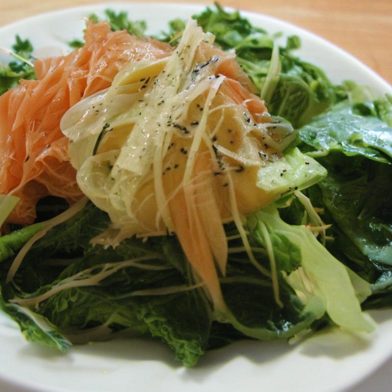 Здоровая пища: квашеная капуста, свежая зелень и лосось на столе